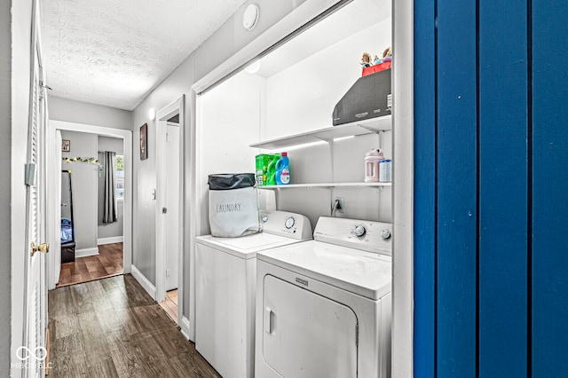 laundry area featuring dark hardwood / wood-style floors, a textured ceiling, and washing machine and clothes dryer