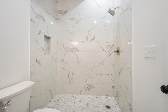 bathroom with toilet and tiled shower