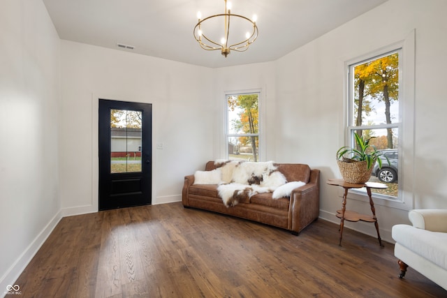 sitting room with a chandelier and dark wood-type flooring