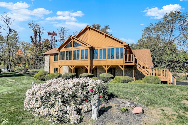 8530 Helmsman Cir, Indianapolis, IN 46256 - rear view of property featuring a sunroom, stone siding, stairs, a yard, and a wooden deck