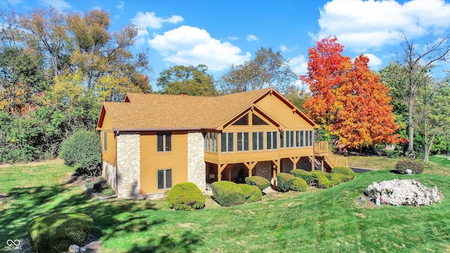 8530 Helmsman Cir, Indianapolis, IN 46256 - back of property featuring stone siding, a sunroom, a yard, a shingled roof, and stairway