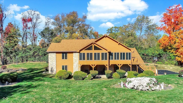 8530 Helmsman Cir, Indianapolis, IN 46256 - rear view of house featuring stone siding, a sunroom, a yard, and stairs