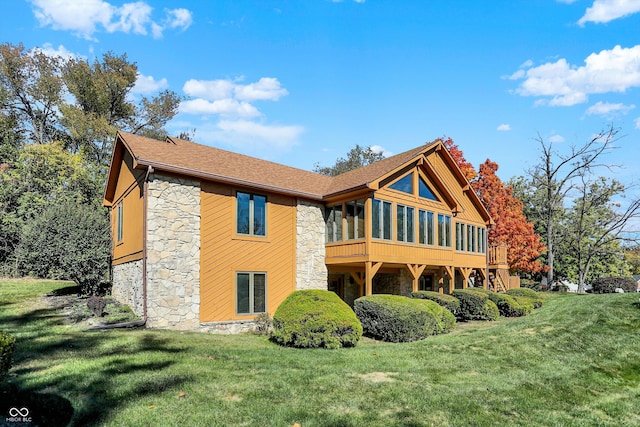 8530 Helmsman Cir, Indianapolis, IN 46256 - back of house featuring stone siding, a sunroom, a lawn, and a shingled roof