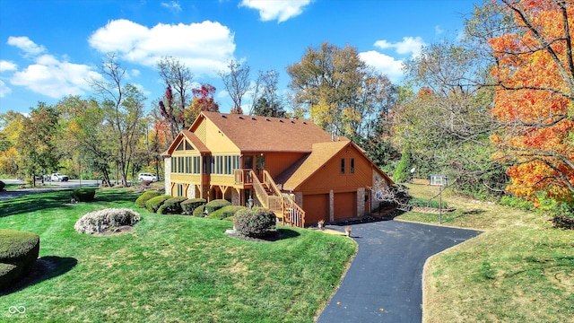 8530 Helmsman Cir, Indianapolis, IN 46256 - view of front facade with stairway, a front yard, asphalt driveway, stone siding, and an attached garage