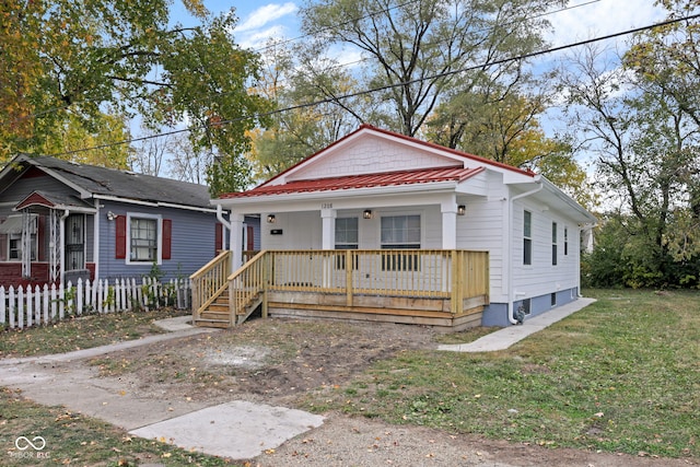 bungalow with covered porch and a front lawn