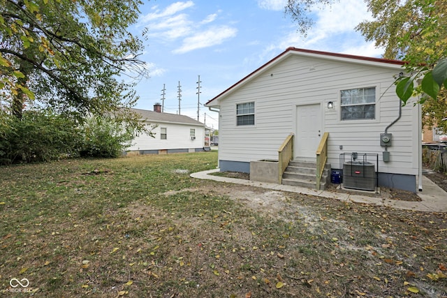 rear view of property with a yard and central AC unit