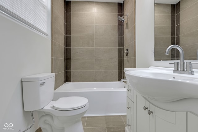 full bathroom with toilet, tiled shower / bath, vanity, and tile patterned flooring