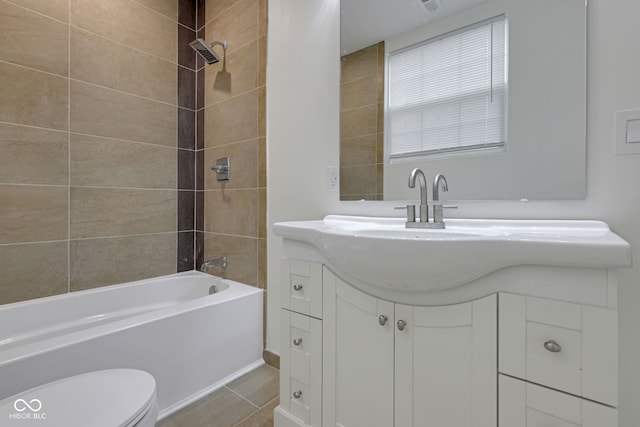 full bathroom featuring vanity, tiled shower / bath combo, toilet, and tile patterned floors