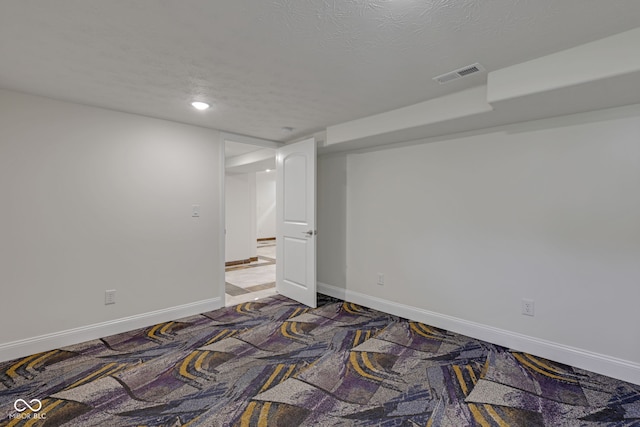 spare room with a textured ceiling and carpet floors