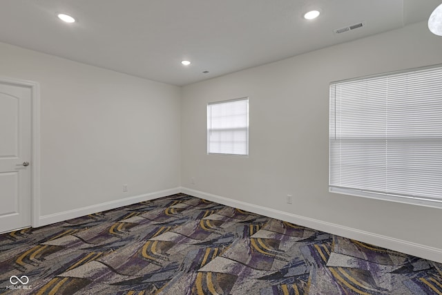 unfurnished room featuring dark colored carpet