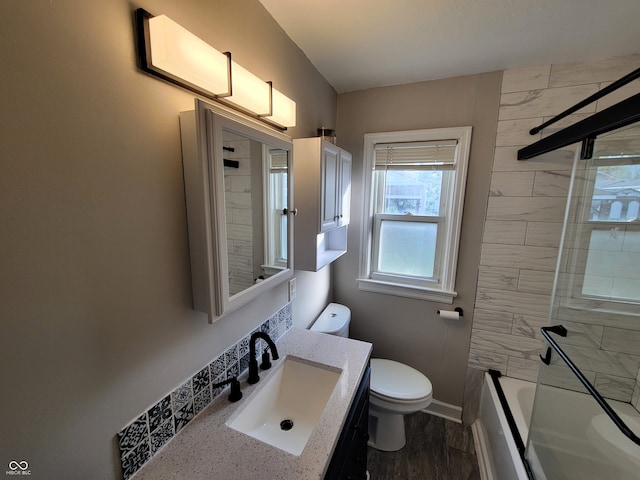 full bathroom featuring tiled shower / bath, vanity, and toilet