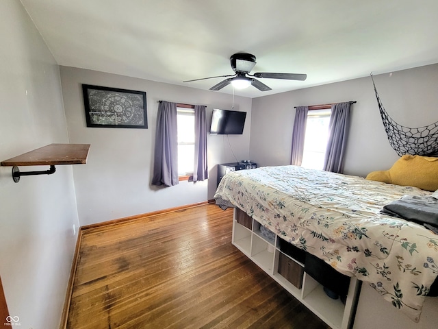 bedroom with hardwood / wood-style floors, multiple windows, and ceiling fan