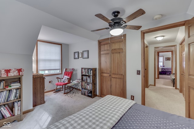 carpeted bedroom with vaulted ceiling, a closet, and ceiling fan