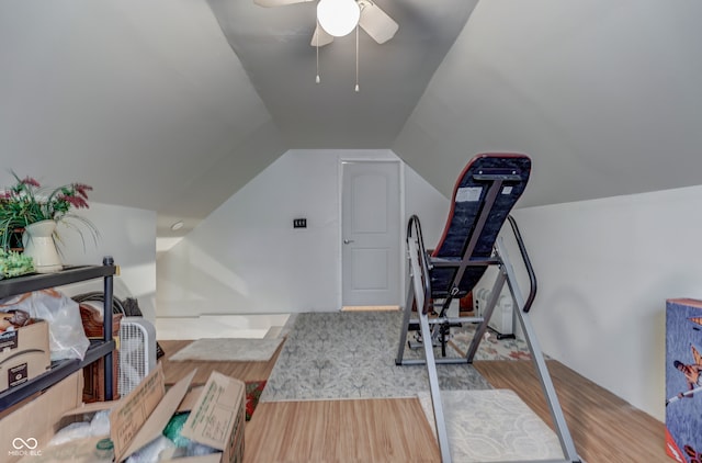 exercise area featuring light hardwood / wood-style floors, vaulted ceiling, and ceiling fan