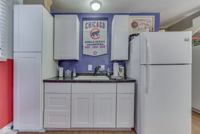 kitchen featuring sink, white cabinetry, light wood-type flooring, and white refrigerator