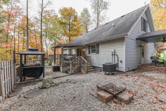 rear view of property featuring central AC, a gazebo, an outdoor fire pit, and a deck