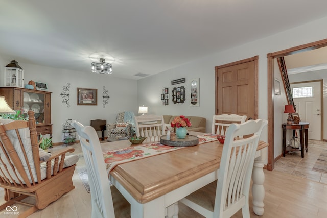 dining room with light hardwood / wood-style flooring and a chandelier