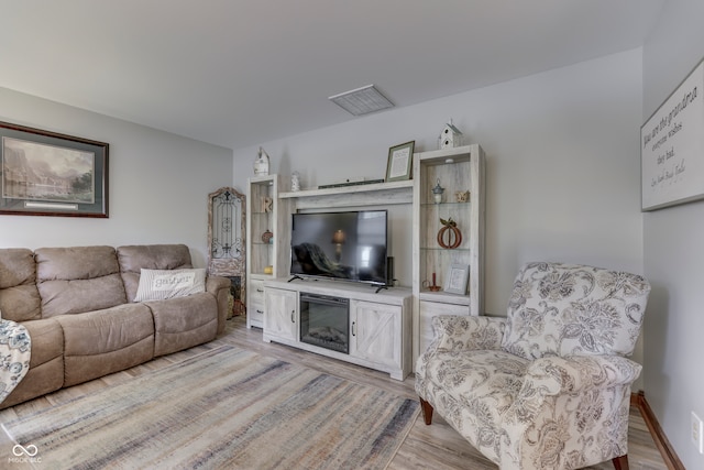 living room with light hardwood / wood-style flooring and a fireplace