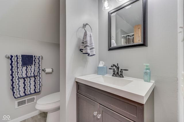 bathroom featuring vanity, toilet, and hardwood / wood-style flooring