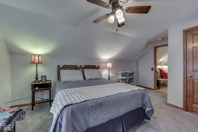 carpeted bedroom featuring lofted ceiling, ensuite bath, and ceiling fan