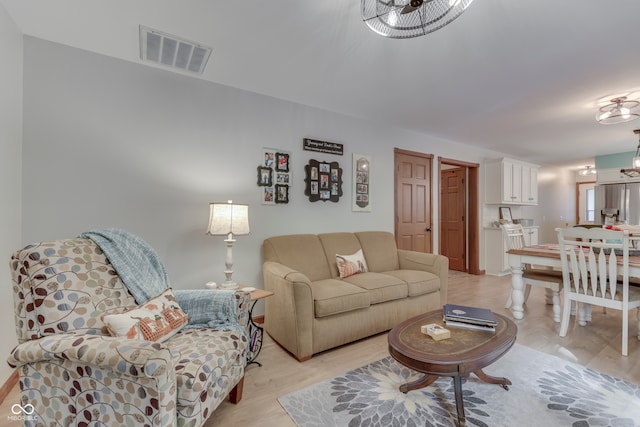 living room featuring an inviting chandelier and light wood-type flooring