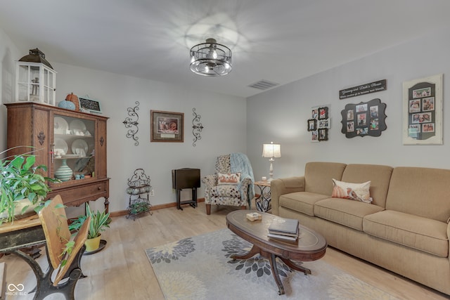 living room with an inviting chandelier and light wood-type flooring