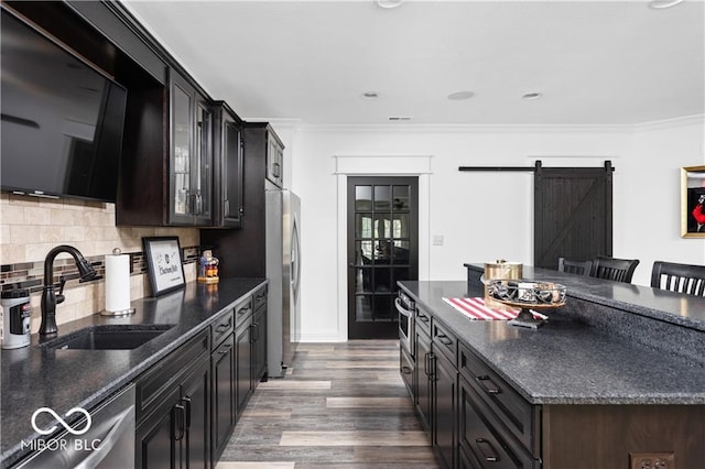 kitchen with stainless steel fridge, sink, a kitchen breakfast bar, and ornamental molding