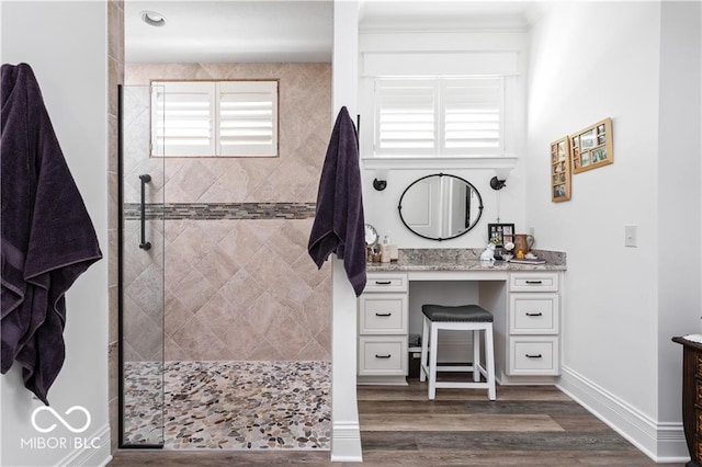 bathroom featuring vanity, a tile shower, and hardwood / wood-style flooring