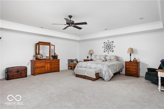 bedroom featuring ceiling fan, crown molding, carpet flooring, and a tray ceiling