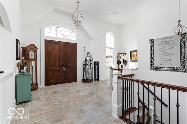 foyer with ornamental molding and a high ceiling