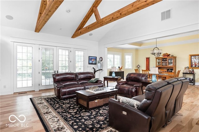 living room with an inviting chandelier, beamed ceiling, high vaulted ceiling, and light hardwood / wood-style floors