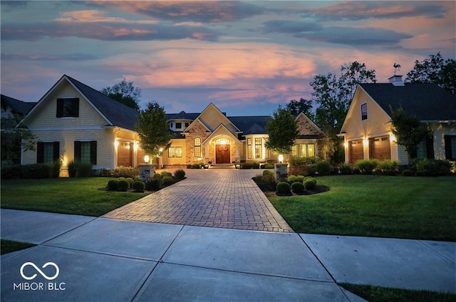 view of front of house with a garage and a lawn