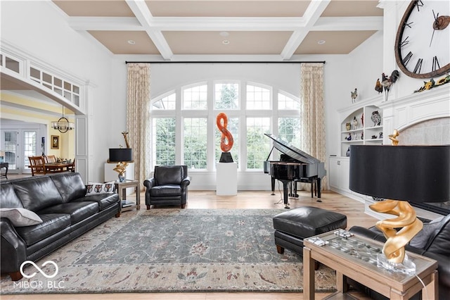 sitting room featuring light hardwood / wood-style floors, coffered ceiling, beamed ceiling, and a chandelier