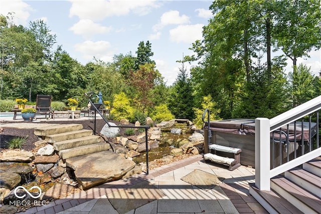 wooden terrace with a hot tub and a patio area