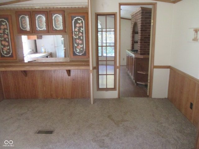 interior space with wood walls and carpet flooring