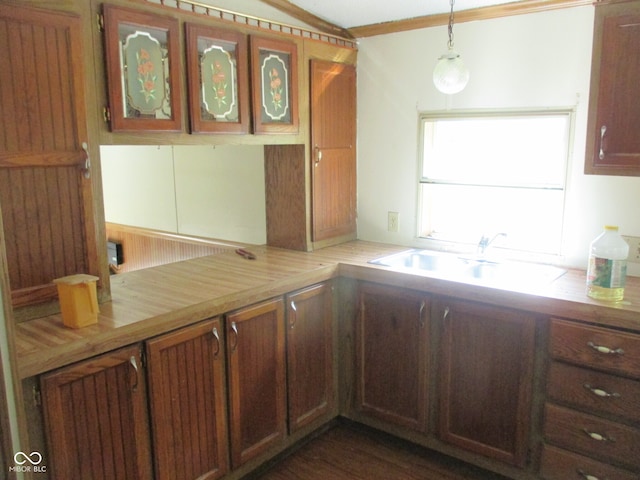 kitchen with sink, crown molding, butcher block countertops, and decorative light fixtures