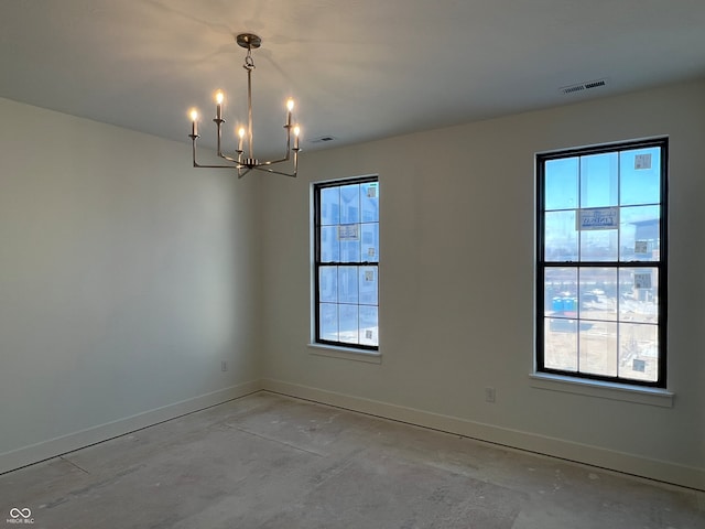 empty room with plenty of natural light and an inviting chandelier