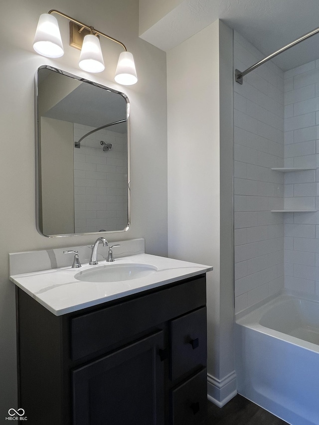 bathroom with tiled shower / bath and vanity