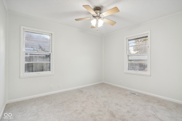 carpeted spare room with crown molding and ceiling fan