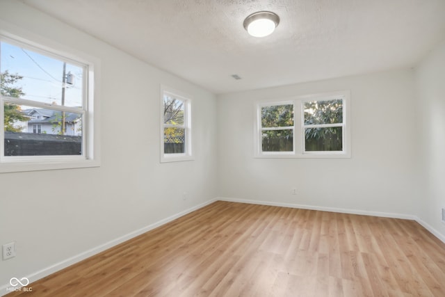 unfurnished room featuring a textured ceiling and light wood-type flooring