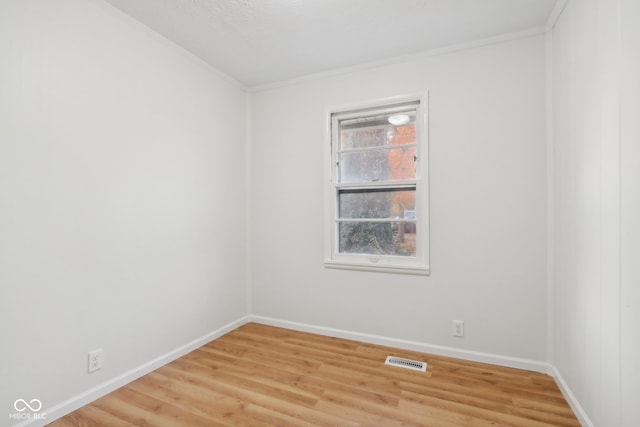 empty room featuring crown molding and light hardwood / wood-style flooring