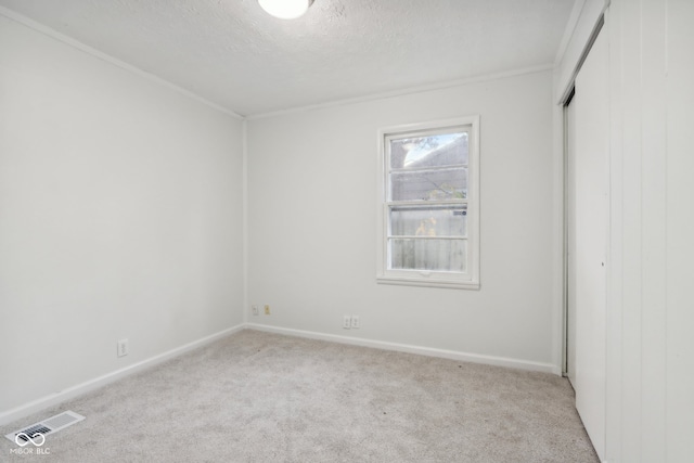 empty room with light carpet and a textured ceiling