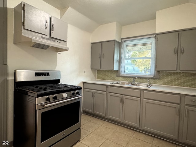 kitchen featuring gas stove, decorative backsplash, sink, and gray cabinets