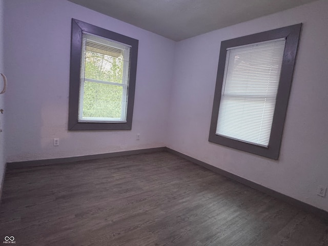 unfurnished room with dark hardwood / wood-style flooring