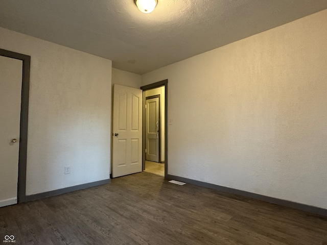 empty room with dark hardwood / wood-style flooring