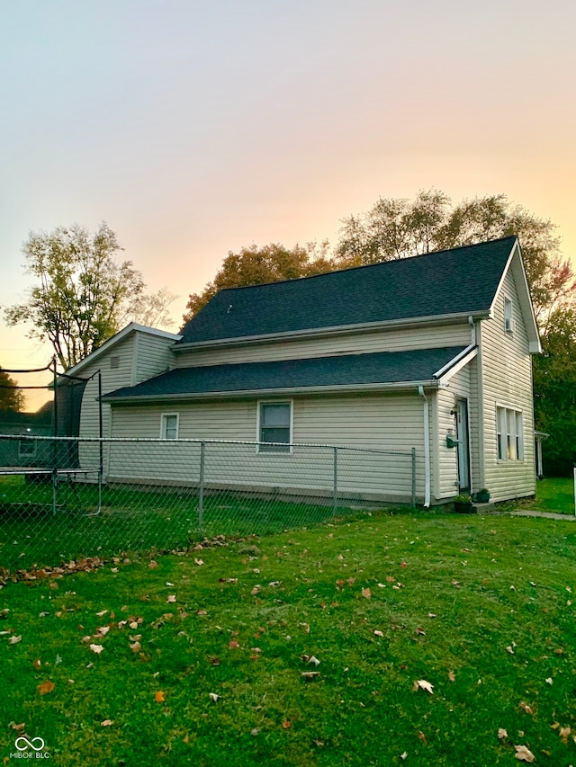 property exterior at dusk with a lawn