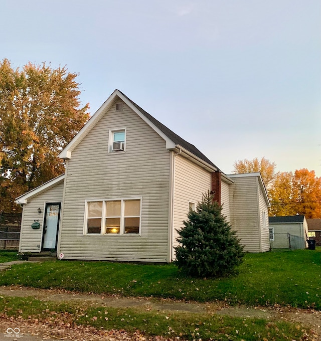 rear view of property featuring a lawn