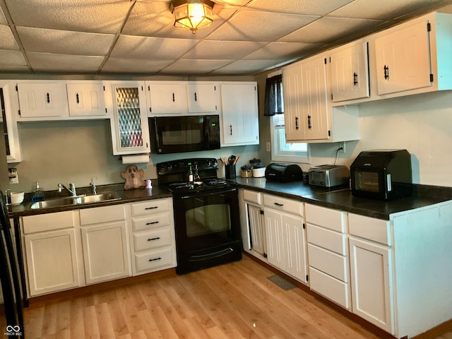 kitchen with sink, black appliances, and white cabinetry