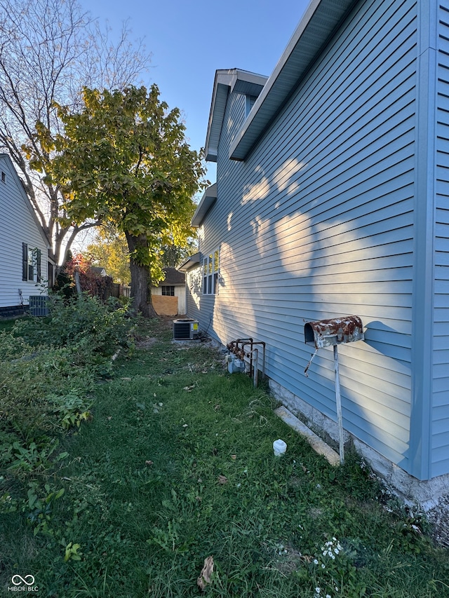 view of property exterior featuring a yard and central AC