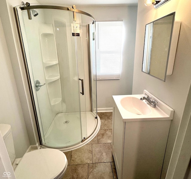 bathroom with tile patterned floors, vanity, toilet, and a shower with shower door